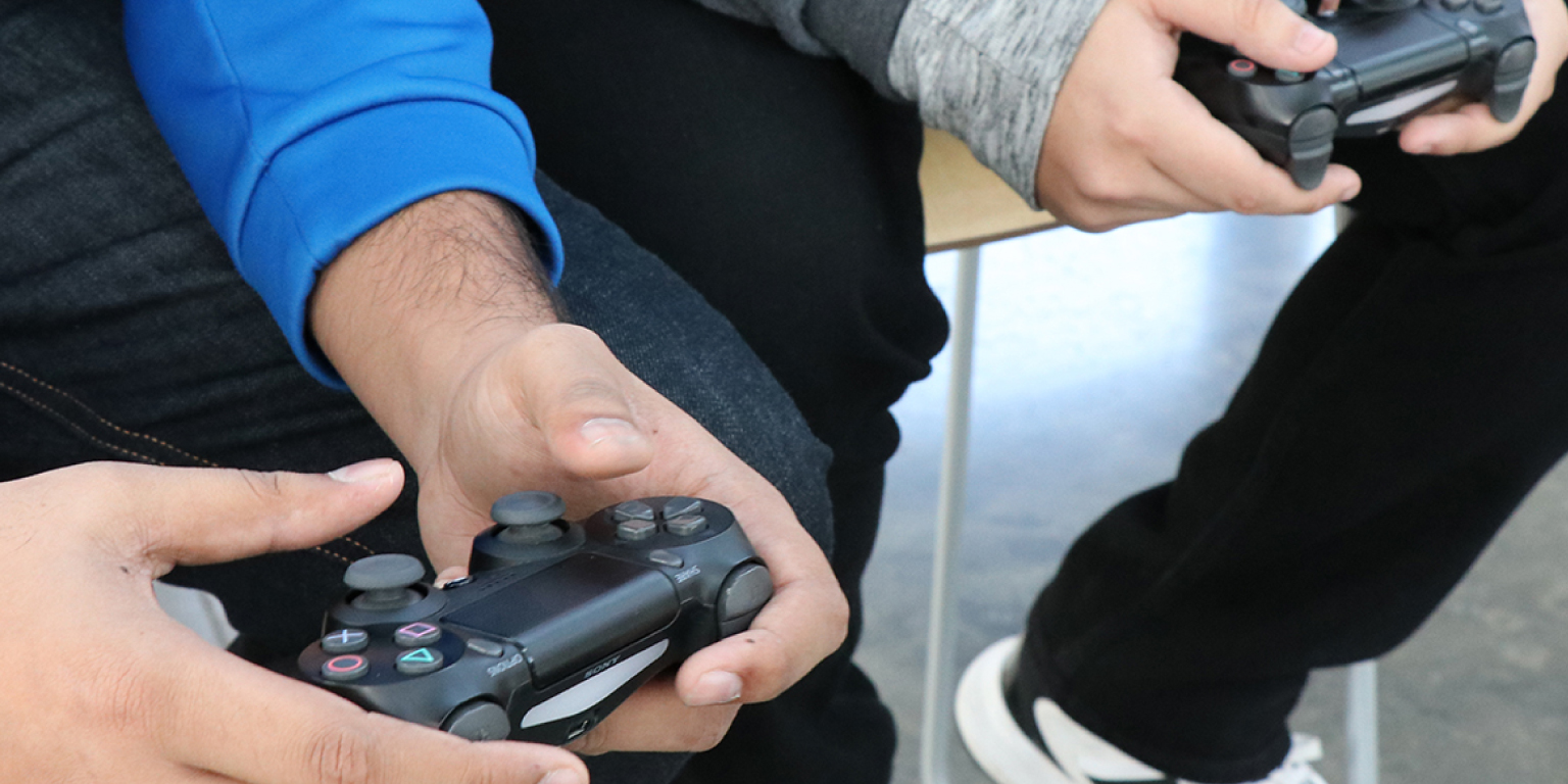 Hands holding a Playstation 4 controller.